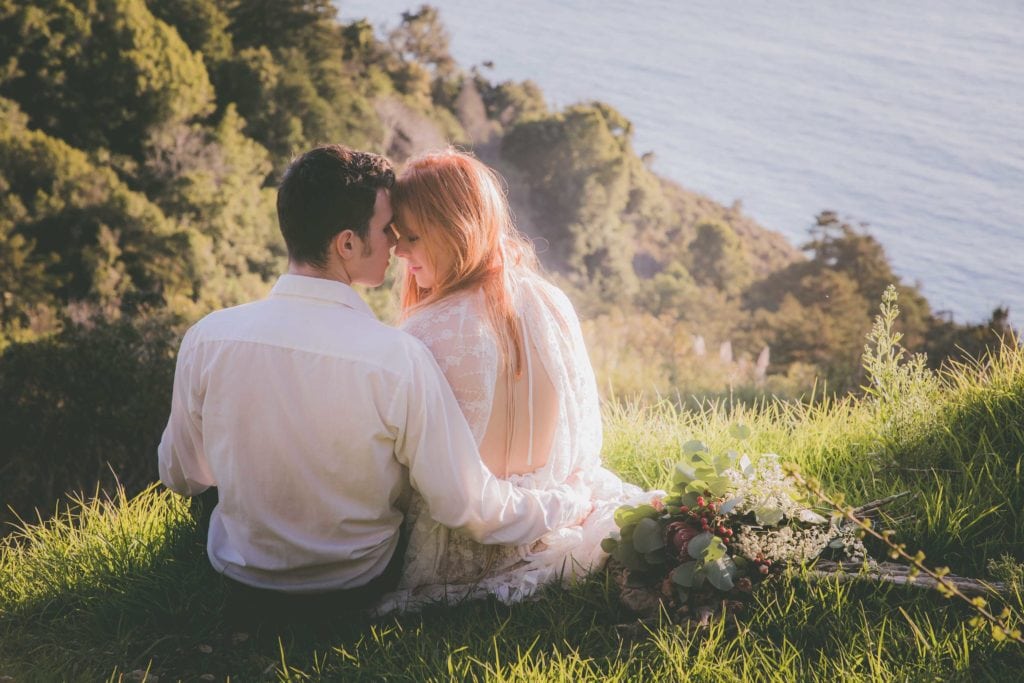 Bride and groom touch foreheads overlooking the ocean in Big Sur.