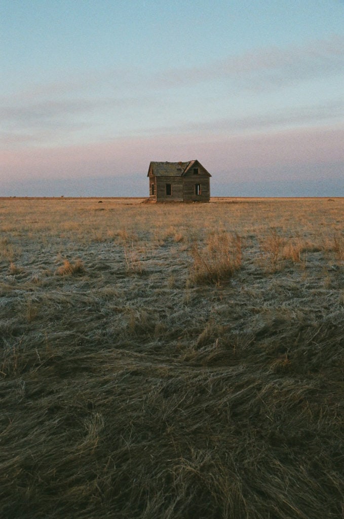 Sunrise at an abandoned cabin in a grassy field in the plains of northeast Montana. 