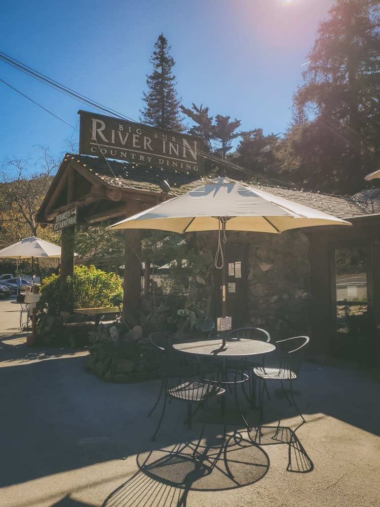 An outdoor patio table set up in the sunlight for patrons of the Big Sur River Inn's restaurant.