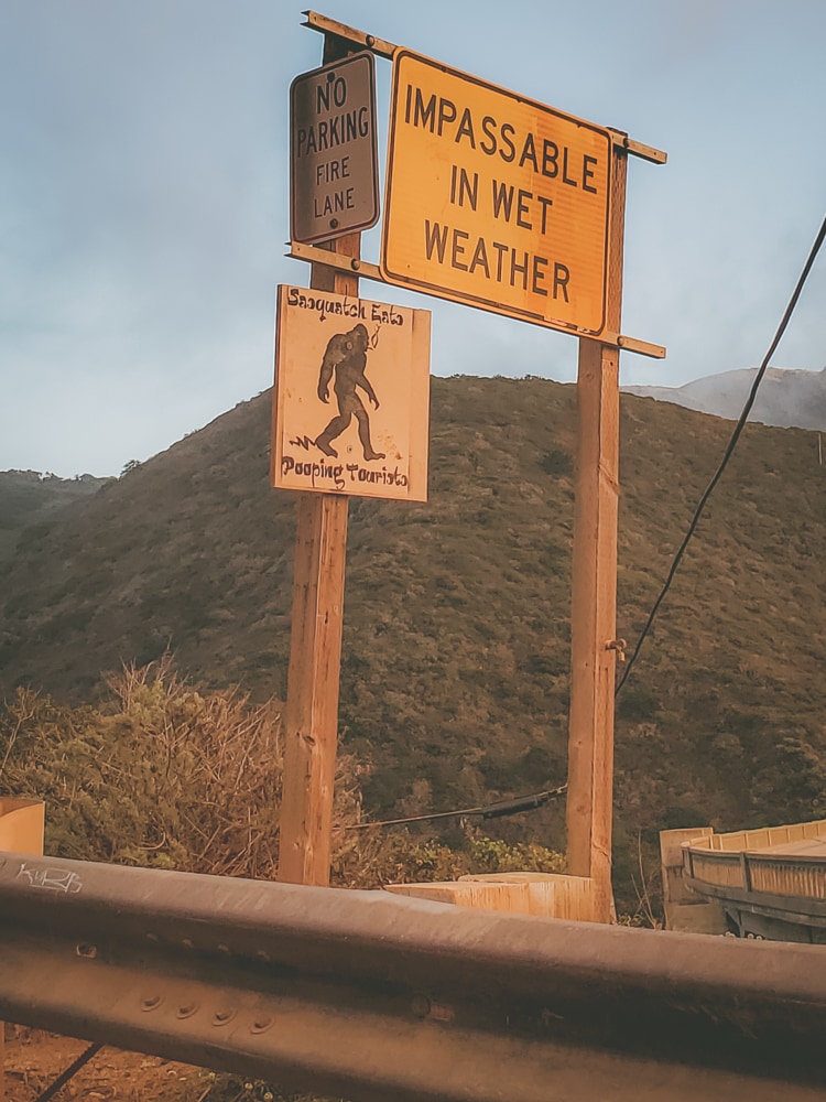 The sign at the beginning of Old Coast Road telling tourists to be respectful of the land and also to be aware of road conditions.